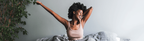 woman stretching waking up in bed
