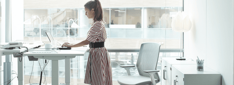 woman at office using a standing desk