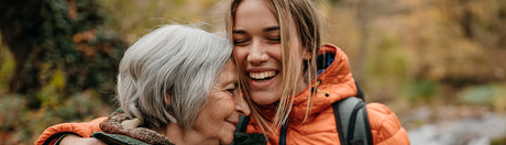 Young and old woman embracing.