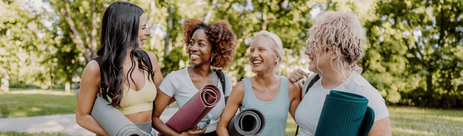 group of 4 women holding yoga mats