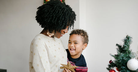 A woman and child decorating a holiday tree.