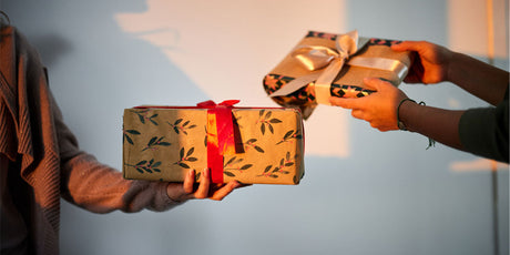 Two people handing each other gifts.