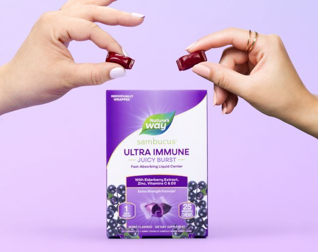 Sambucus Ultra Immune Juicy Burst Pack and hands holding the product