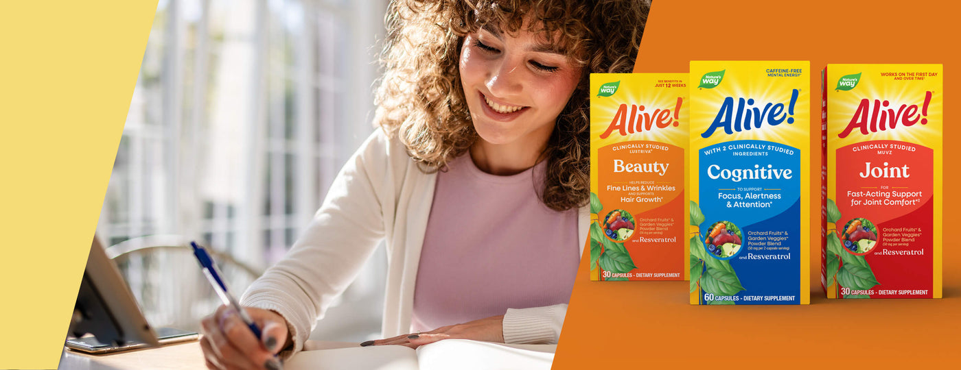 Woman studying with 'Alive!' supplement boxes on an orange background