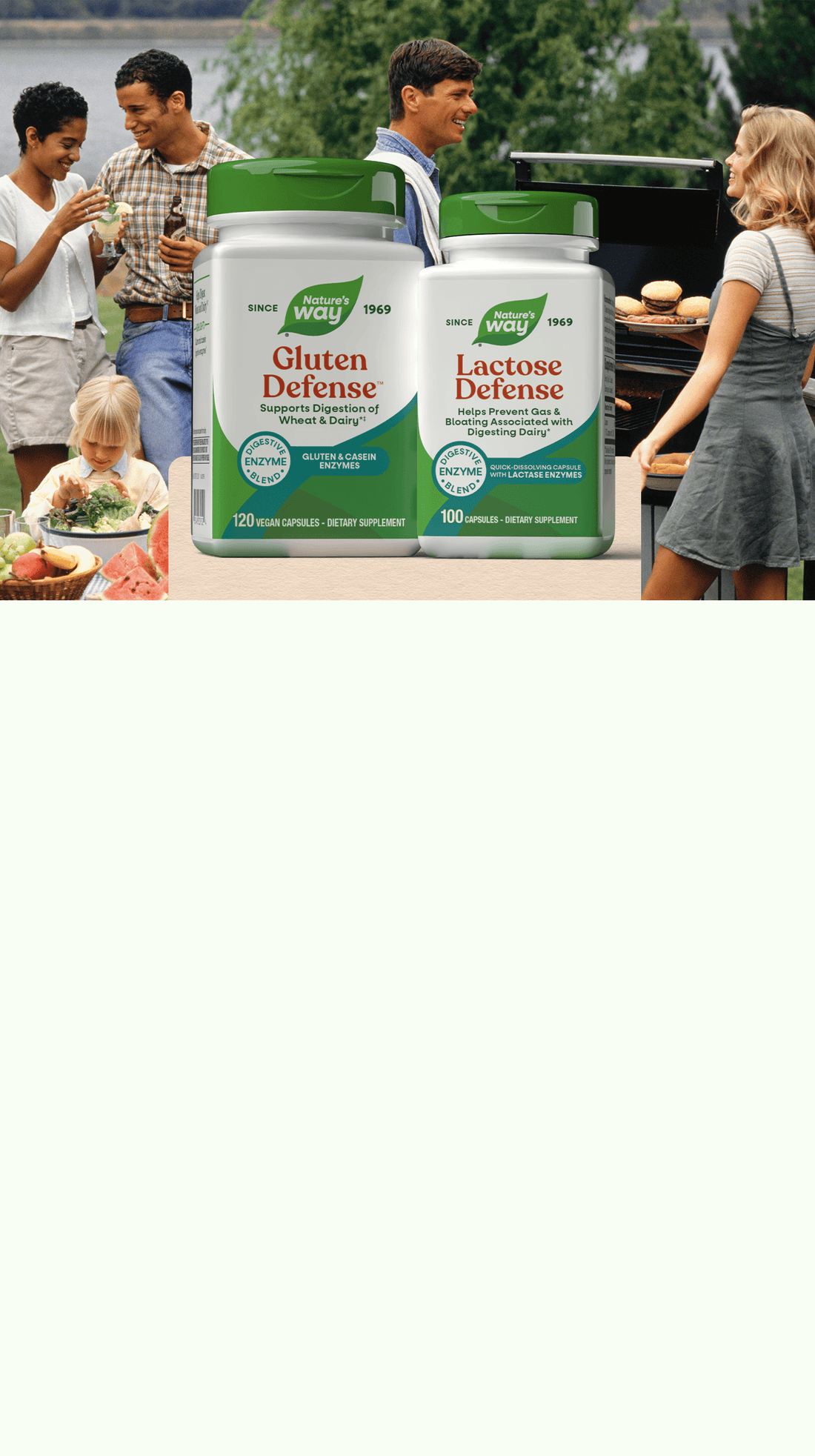 Two containers of Gluten Defense and Lactose Defense supplements on a table with people in the background.