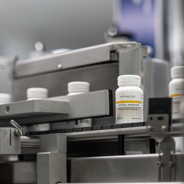 Bottles of a supplement labeled 'Integrative Therapeutics' on an assembly line.